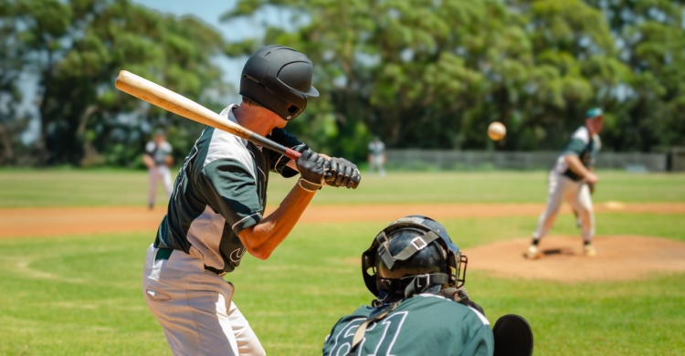 A teenage baseball player stands at bat