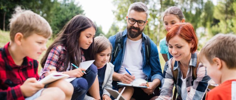 A group of students discuss science with their teachers during a field trip