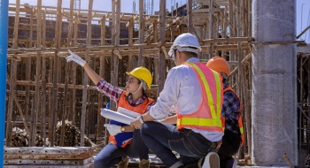 construction workers discuss project plans at a busy worksite